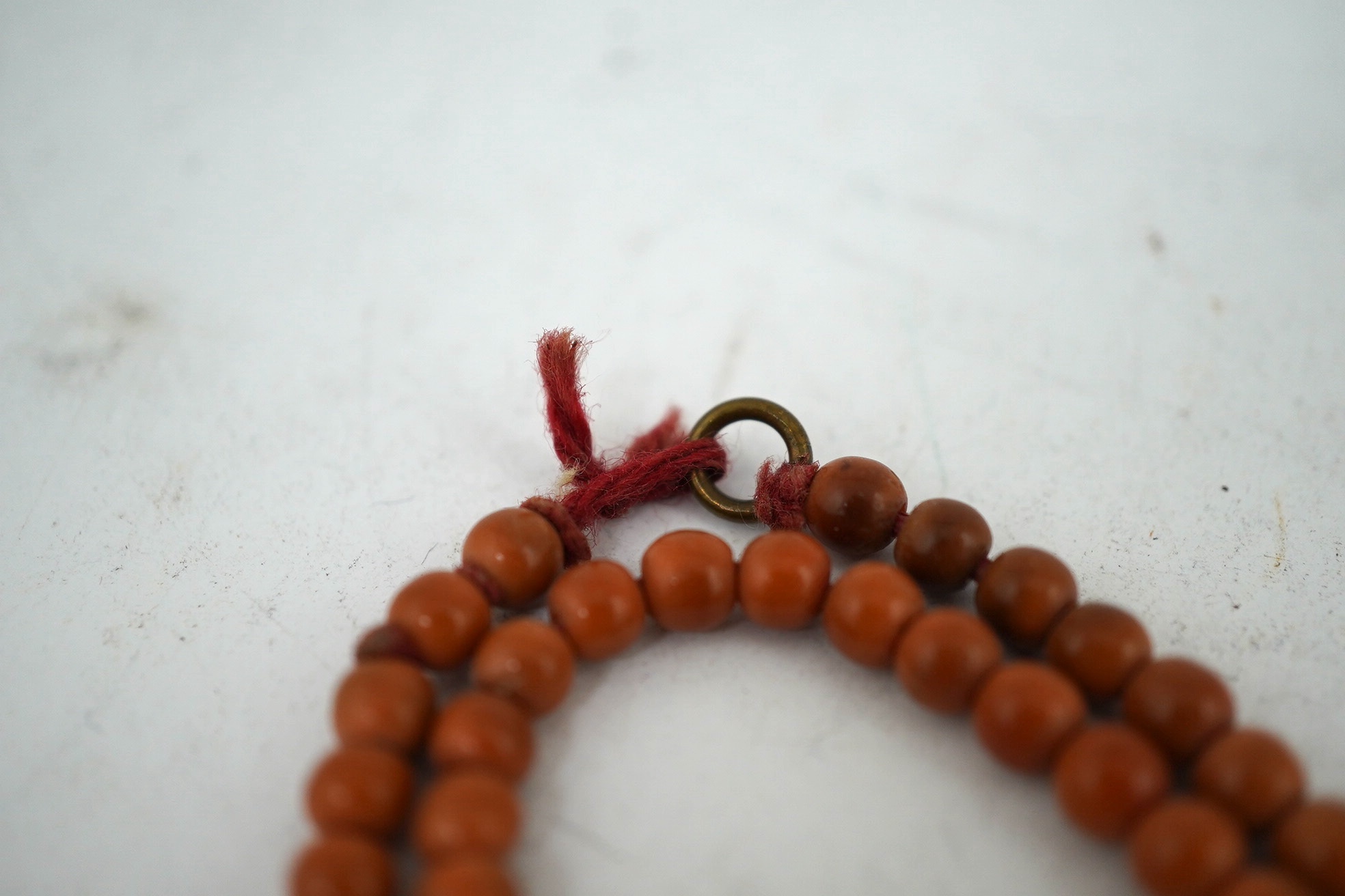 A Chinese coral bead rosary, 58cm drop and a pink soapstone bead necklace, 19.5cm. Condition - fair